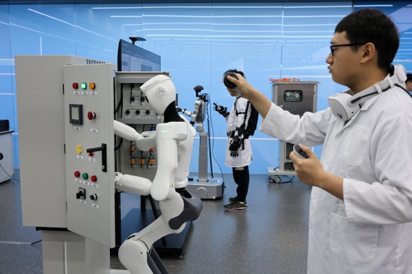 An employee of China Southern Power Grid demonstrates controlling a humanoid robot at the company’s robotics laboratory in Guangzhou. Photo: Reuters