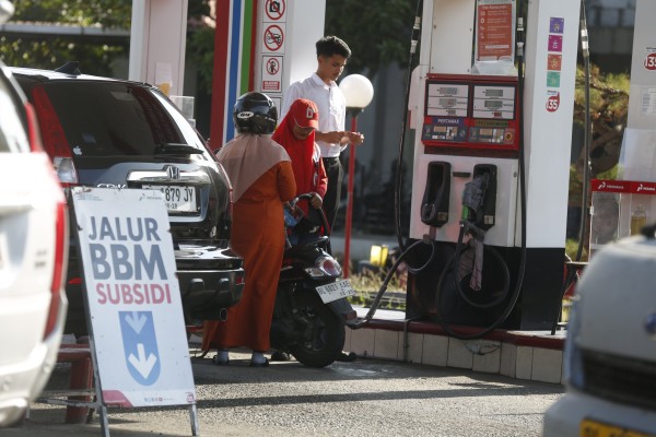 A worker refuels a motorbike at a petrol station in Banda Aceh, Indonesia, on April 20. Photo: EPA