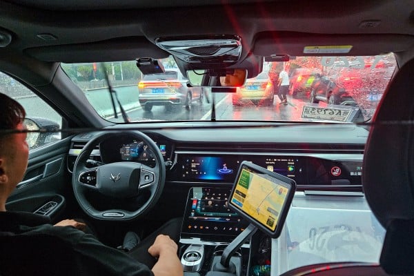 A safety operator sits in the driver’s seat of an Apollo Go robotaxi as the vehicle travels to Wuhan Tianhe International Airport. Photo: Coco Feng A safety operator sits in the driver’s seat of an Apollo Go robotaxi as the vehicle travels to Wuhan Tianhe International Airport. Photo: Coco Feng