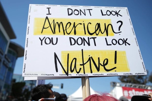 A sign at an anti-racism rally. A new survey highlights the ongoing harassment faced by Asian-Americans. Photo: Getty Images A sign at an anti-racism rally. A new survey highlights the ongoing harassment faced by Asian-Americans. Photo: Getty Images