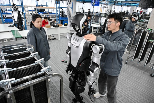 Employees work with a robot at the Qingdao Humanoid Robot Data and Training Centre in Shandong province, on March 23. Photo: Xinhua