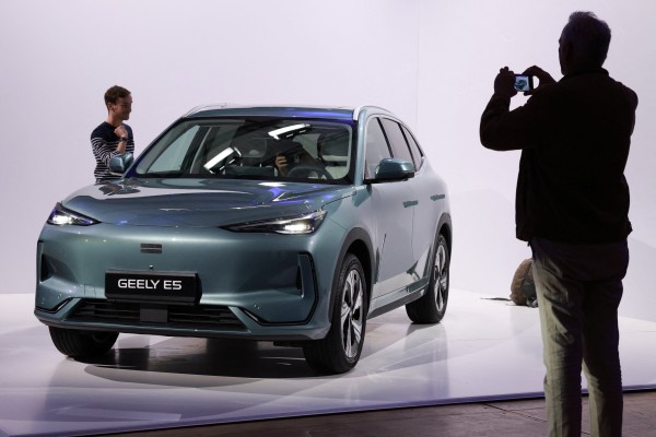 A journalist takes pictures of the Geely E5 electric compact SUV car presented at the launch of Geely Auto France in Paris on April 28. Photo: Reuters