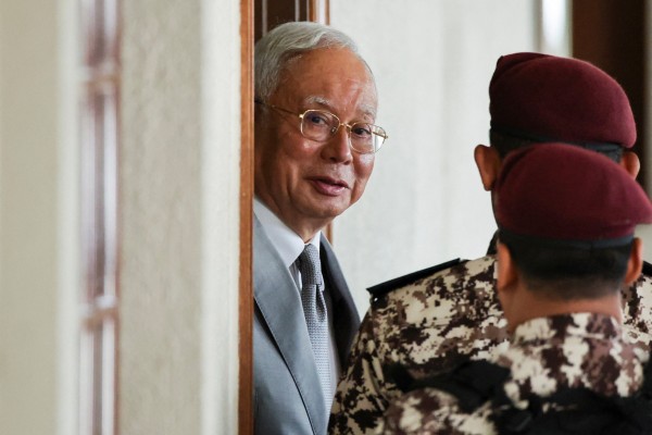 Malaysia’s former prime minister Najib Razak is escorted by prison guards at Kuala Lumpur Courts Complex in December 2025. Photo: Reuters