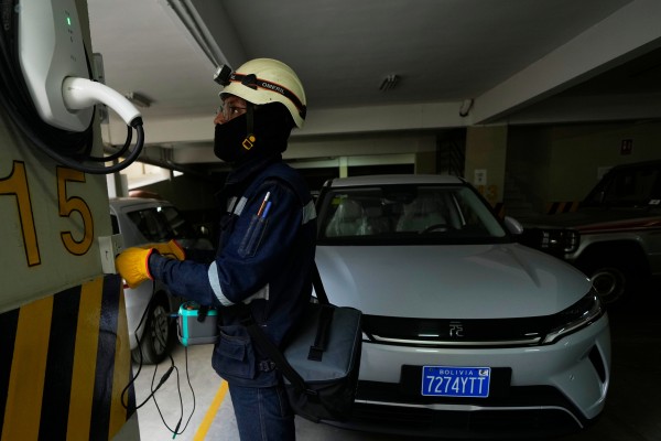 An electrician installs a home electric vehicle charging station in La Paz, Bolivia, on April 21. Photo: AP