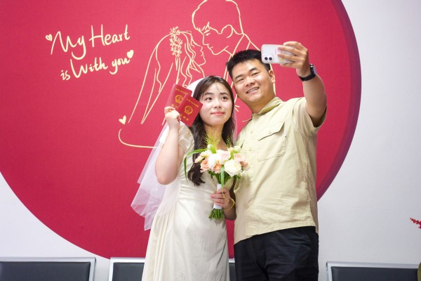 A newlywed couple takes a selfie with their marriage certificates at a marriage registration office in China’s northern Henan province. Photo: Getty Images A newlywed couple takes a selfie with their marriage certificates at a marriage registration office in China’s northern Henan province. Photo: Getty Images