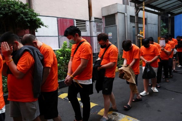 Foreign nationals suspected of running an online gambling operation at an office building in Jakarta await transport after being arrested in the Indonesian capital on Sunday. Photo: Reuters Foreign nationals suspected of running an online gambling operation at an office building in Jakarta await transport after being arrested in the Indonesian capital on Sunday. Photo: Reuters