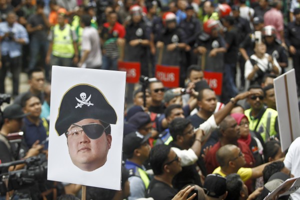 A protester holds a poster of Jho Low  as a pirate during a rally in Kuala Lumpur on April 14, 2018. Photo: AP