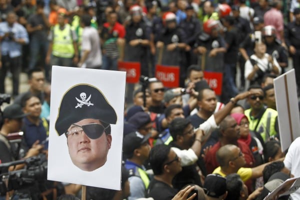 A protester holds a poster of Jho Low as a pirate during a rally in Kuala Lumpur on April 14, 2018. Photo: AP A protester holds a poster of Jho Low as a pirate during a rally in Kuala Lumpur on April 14, 2018. Photo: AP