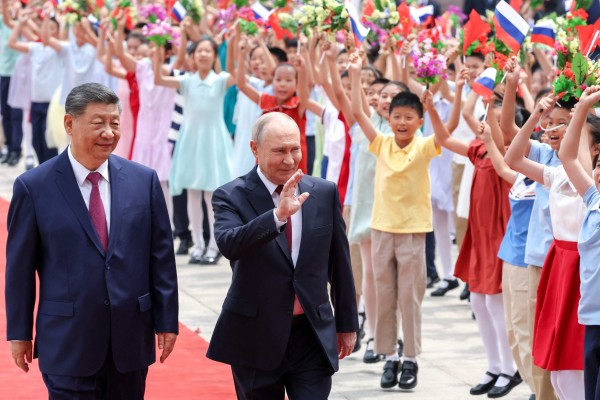 Presidents Xi Jinping and Vladimir Putin wave to a group of children at a welcome ceremony for the Russian leader in Beijing on May 20. Photo: Pool via AFP