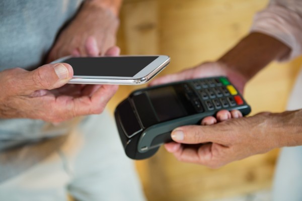 A consumer makes a payment using a mobile phone. Photo: Shutterstock