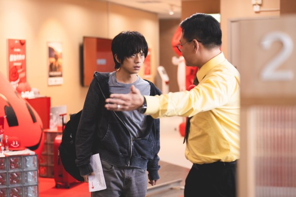 Yukki Tai as the frustrated Tak (left) and Michael Ning as desk agent Ringo in a still from Dog Day Evening.