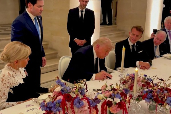 US President Donald Trump (centre) signs a memorandum of understanding with Iran in Versailles, France on June 17 as French President Emmanuel Macron (right) and his wife Brigitte Macron (left) look on. Photo: AFP and X/Scavino47