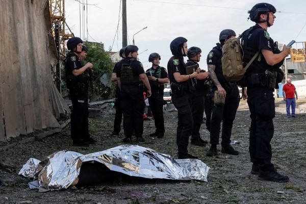 Police officers stand near the body of a resident killed during a Russian air strike in Kharkiv, Ukraine, on Monday. Photo: Reuters