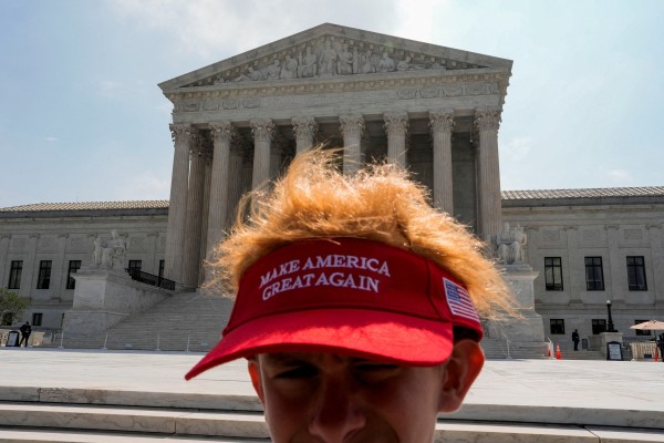 A person wears a MAGA (Make America Great Again) visor outside the U.S. Supreme Court, on the day justices have issued orders, in Washington, D.C., U.S., June 29, 2026.  REUTERS/Cheney Orr     TPX IMAGES OF THE DAY