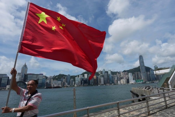 A man holds a national flag at the Tsim Sha Tsui waterfront on the anniversary of Hong Kong’s return to Chinese rule. Photo: Jelly Tse A man holds a national flag at the Tsim Sha Tsui waterfront on the anniversary of Hong Kong’s return to Chinese rule. Photo: Jelly Tse