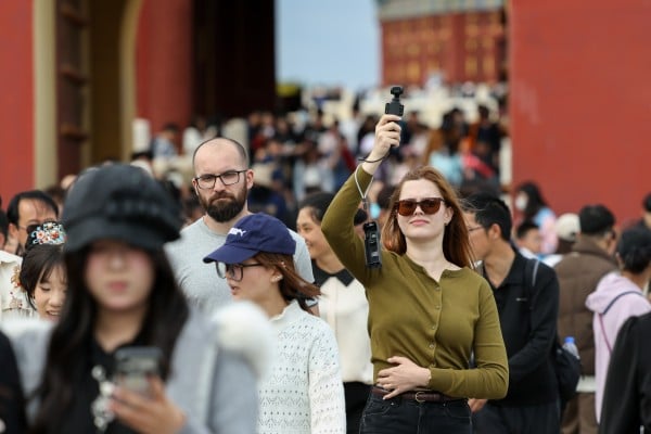 A foreign tourist records with a Chinese-brand pocket camera at the Temple of Heaven Park in Beijing on May 2. Photo: Xinhua A foreign tourist records with a Chinese-brand pocket camera at the Temple of Heaven Park in Beijing on May 2. Photo: Xinhua