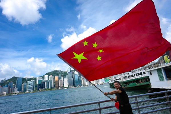 A resident waves the national flag at the Tsim Sha Tsui waterfront as Hong Kong celebrates the 29th anniversary of its return to Chinese rule and the 105th anniversary of the Communist Party. Photo: Jelly Tse