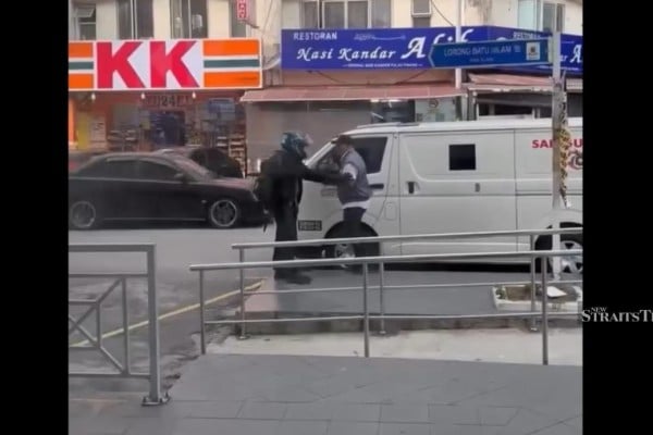 A screengrab shows a robber holding up a security guard outside a bank in Klang on Monday. Photo: Instagram/suaramalaysiabaru A screengrab shows a robber holding up a security guard outside a bank in Klang on Monday. Photo: Instagram/suaramalaysiabaru
