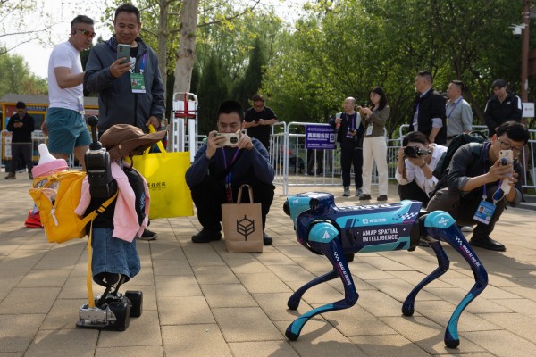 A child-like humanoid robot and dog-like robot interact at the second Beijing E-Town Half Marathon and Humanoid Robot Half Marathon in Beijing on April 19. Photo: EPA