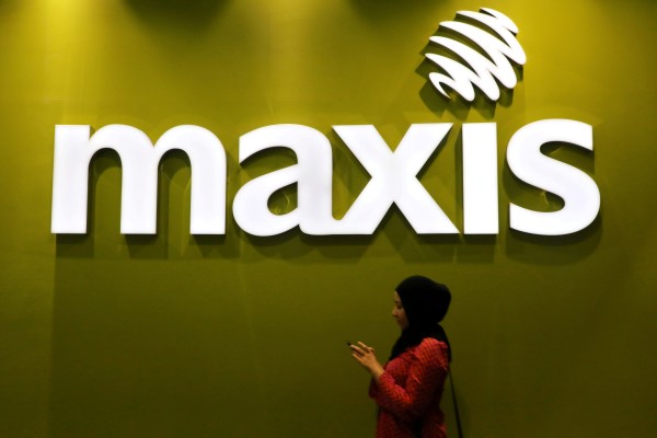 A woman walks past a logo of Maxis at its headquarters in Kuala Lumpur. A bill leak involving an influencer has raised concerns about data protection. Photo: Reuters