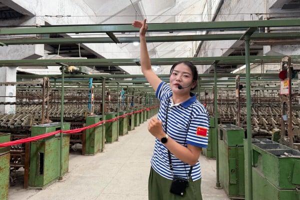 A Xinjiang guide explains the region’s history of cotton production during a factory tour. Photo: Edith Lin A Xinjiang guide explains the region’s history of cotton production during a factory tour. Photo: Edith Lin