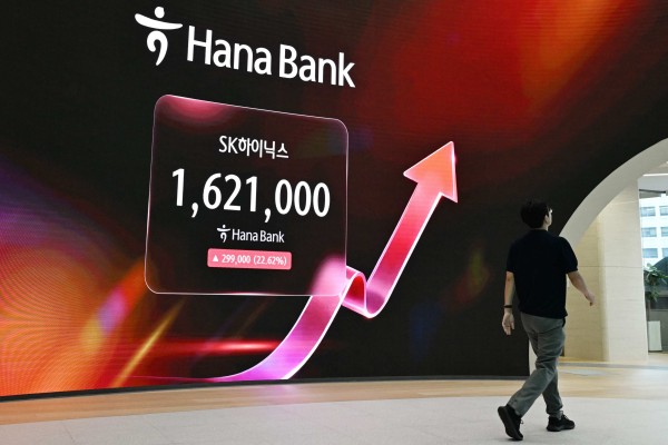 A man walks past an electronic screen showing the SK Hynix stock price outside a foreign exchange dealing room at the Hana Bank headquarters in Seoul on July 31. Photo: AFP