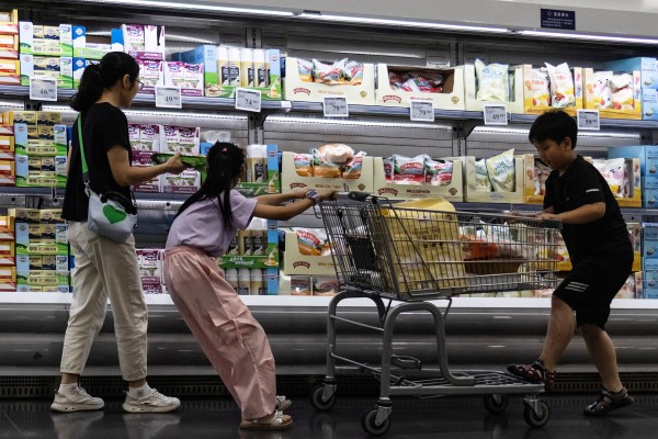 A woman and two children shop in front of a refrigerated cheese shelf at a supermarket in Beijing on July 10. Photo: Reuters