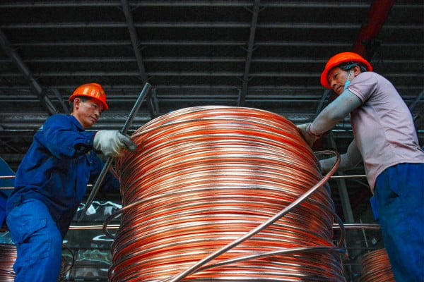 Employees wind copper rods at a workshop that recycles copper in China’s Anhui province. Photo: AFP Employees wind copper rods at a workshop that recycles copper in China’s Anhui province. Photo: AFP