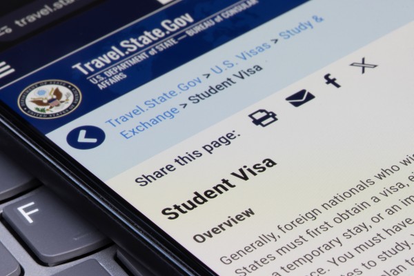 The US Department of State website’s student visa page on the screen of a smartphone. Photo: Shutterstock Images