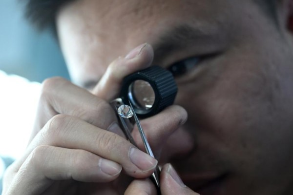 A worker checks a diamond at a facility in China’s Henan province. Photo: Xinhua