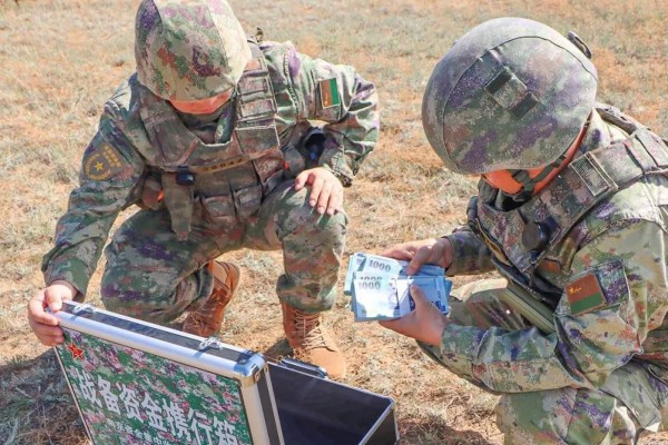 A state newspaper report that has since been deleted included photos of PLA troops counting bundles of New Taiwan dollars delivered by drone during a drill. Photo: qq.com