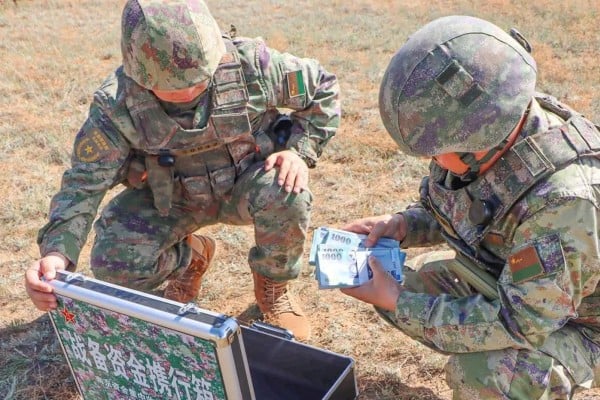 A state newspaper report that has since been deleted included photos of PLA troops counting bundles of New Taiwan dollars delivered by drone during a drill. Photo: qq.com A state newspaper report that has since been deleted included photos of PLA troops counting bundles of New Taiwan dollars delivered by drone during a drill. Photo: qq.com