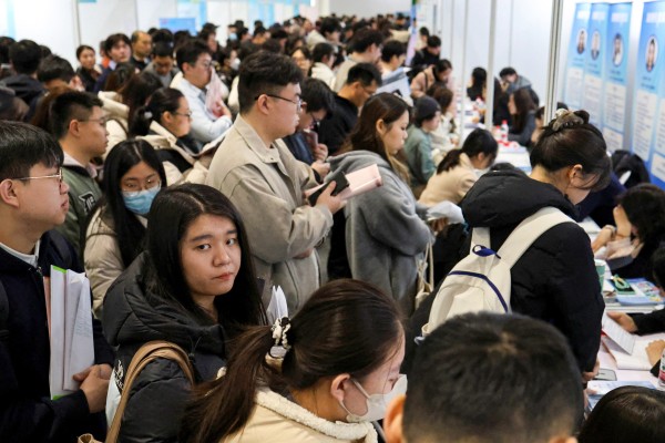 People line up at career guidance booths at a job fair in Beijing in March. Photo: Reuters