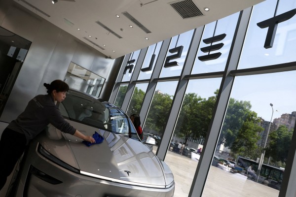 A staff member cleans an electric car inside a Tesla store in Beijing. Photo: Reuters