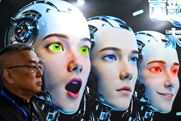 A man stands next to a poster showing robots mimicking human expressions from Shenzhen Xiaoquan Technology during the International AI Application and Robotics Innovation Exhibition in Beijing on March 18. Photo: AFP