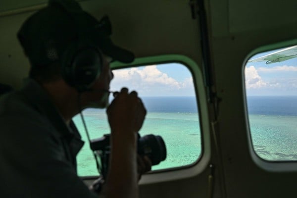 A Philippine coastguard personnel talks on a mic as he looks over Scarborough Shoal in the disputed South China Sea in June. Photo: AFP A Philippine coastguard personnel talks on a mic as he looks over Scarborough Shoal in the disputed South China Sea in June. Photo: AFP