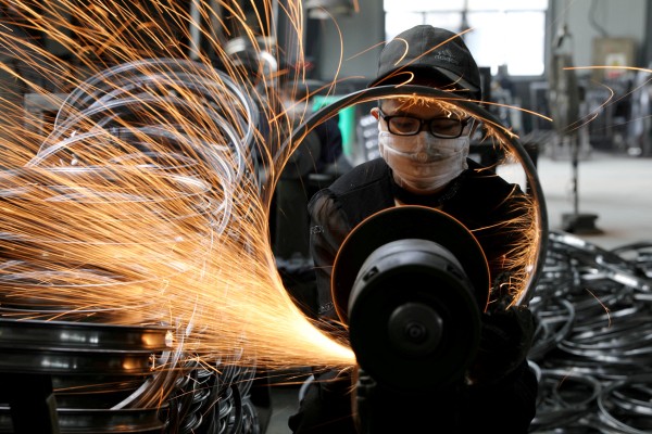 A worker polishes a steel bicycle rim at a factory manufacturing sports equipment in Hangzhou, Zhejiang province. Photo: Reuters