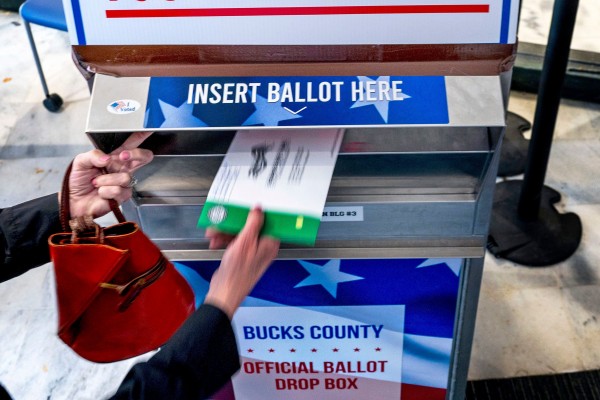 A voter places a mail ballot into a drop box. About 30 per cent of Americans vote by mail, according to state election data. Photo: TNS A voter places a mail ballot into a drop box. About 30 per cent of Americans vote by mail, according to state election data. Photo: TNS