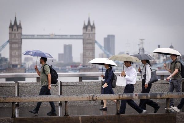 Commuters cross London Bridge during heavy rainfall in Britain on Thursday. Photo: EPA Commuters cross London Bridge during heavy rainfall in Britain on Thursday. Photo: EPA