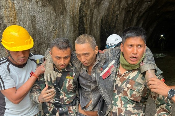 A Chinese man (second from right) was rescued from a tunnel in Nepal on Saturday, over a week after fatal flash floods devastated river valleys along the China-Nepal border. Photo: Army handout via EPA