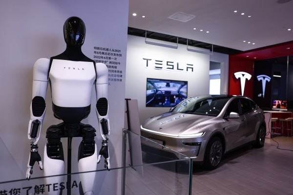 A Tesla humanoid robot and a Model Y electric vehicle are displayed in a store in Beijing in August. Photo: EPA