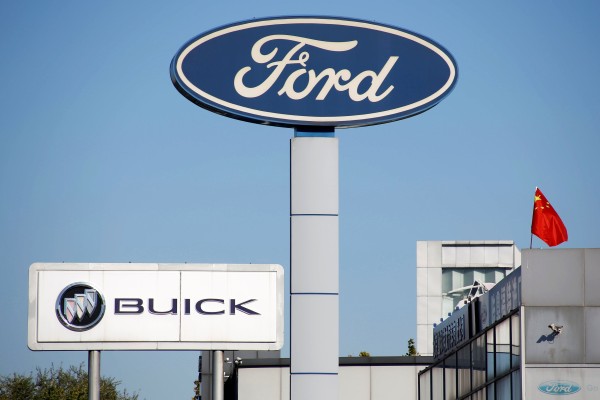 The Chinese national flag flies on the roof of a car dealership near the brand logos of carmakers, including Ford, in Beijing in October 2018. Photo: Reuters