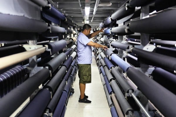 An employee arranges fabrics at a clothing factory in Dalian, Liaoning province, last month. Photo: Xinhua An employee arranges fabrics at a clothing factory in Dalian, Liaoning province, last month. Photo: Xinhua