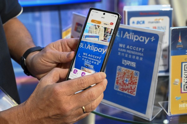 A man demonstrates in April how a QR code is used to make a retail payment with the Alipay app in Indonesia. Kazakhstan now plans to launch QR-code payments with China by the end of this year. Photo: Xinhua