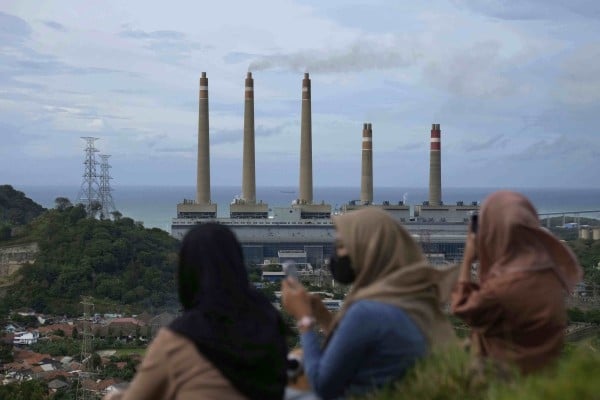 Women sit on a hill overlooking a coal power plant in Indonesia. The country is a hotspot for Chinese energy investment. Photo: AP Women sit on a hill overlooking a coal power plant in Indonesia. The country is a hotspot for Chinese energy investment. Photo: AP