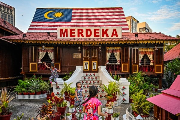Children play outside a traditional Malay wooden house in Melaka city. Photo: AFP Children play outside a traditional Malay wooden house in Melaka city. Photo: AFP