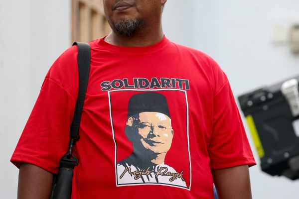 A supporter of the former Malaysian prime minister Najib Razak stands outside Razak’s house in Kuala Lumpur on Monday. Photo: EPA