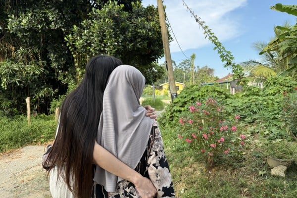 Hana* (left) embraces her mother outside their home in a village near Kota Bharu, Malaysia’s Kelantan state. Photo: Iman Muttaqin Yusof
Hana* (left) embraces her mother outside their home in a village near Kota Bharu, Malaysia’s Kelantan state. Photo: Iman Muttaqin Yusof