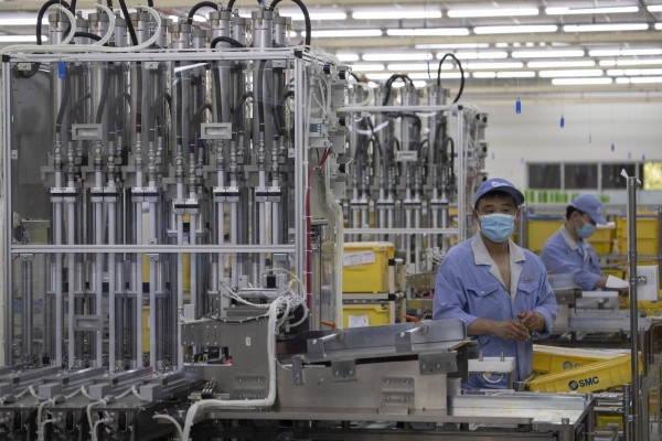 Workers at SMC, a Japanese pneumatic engineering company, assemble products at a factory in Beijing. Photo: AP
