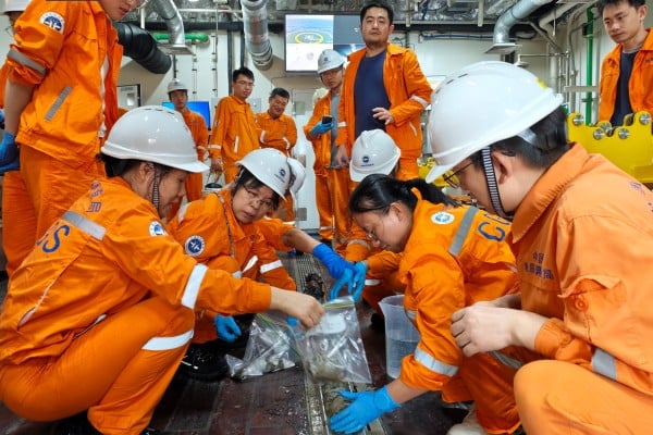 Researchers on board the Chinese ocean drilling vessel Mengxiang retrieve a deep-sea sample during a drilling operation in the South China Sea basin. Photo: CCTV Researchers on board the Chinese ocean drilling vessel Mengxiang retrieve a deep-sea sample during a drilling operation in the South China Sea basin. Photo: CCTV